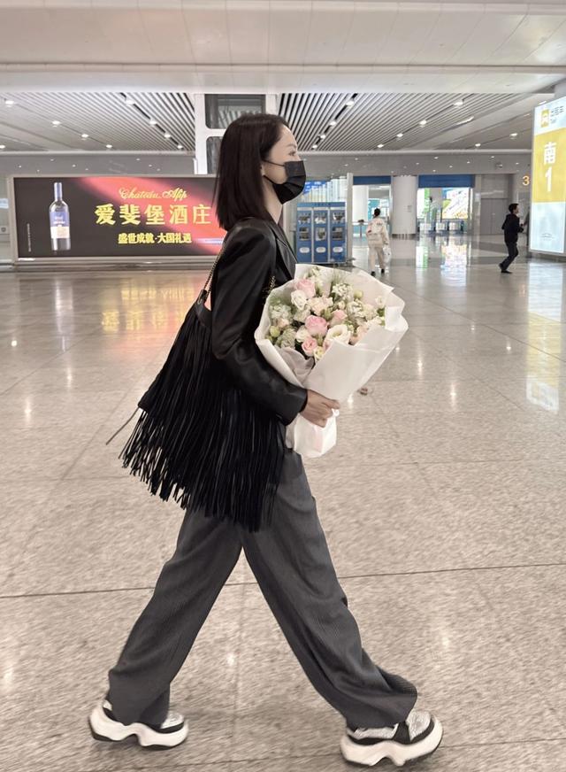 董璇休闲穿搭现身高铁站 手捧鲜花笑意难藏