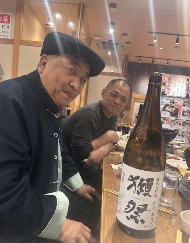 74岁姜昆现身日本聚会，与美女合影没架子，桌上茅台抢镜