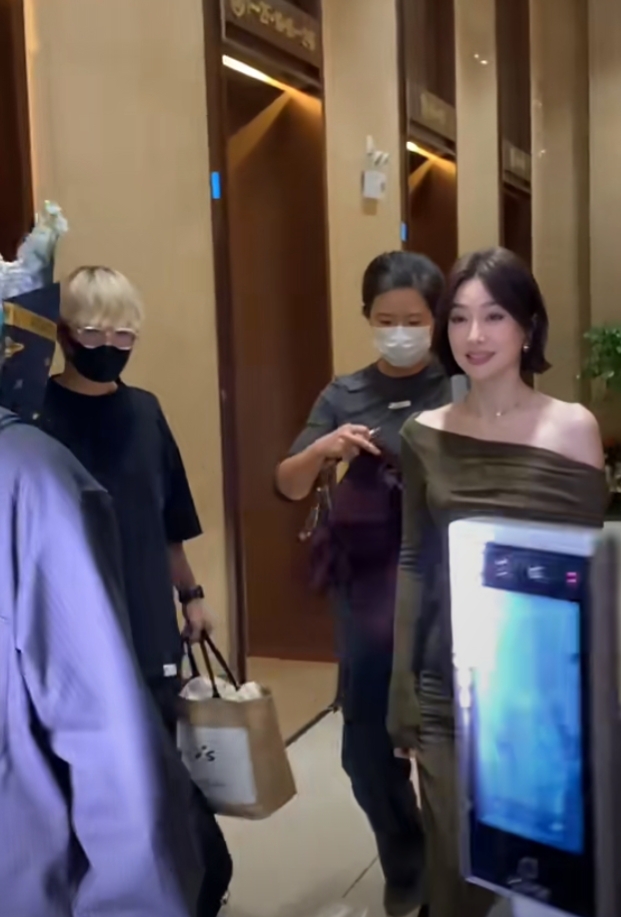 秦岚抵达广州出席活动，墨绿长裙搭酒红披巾，短发超有韵味