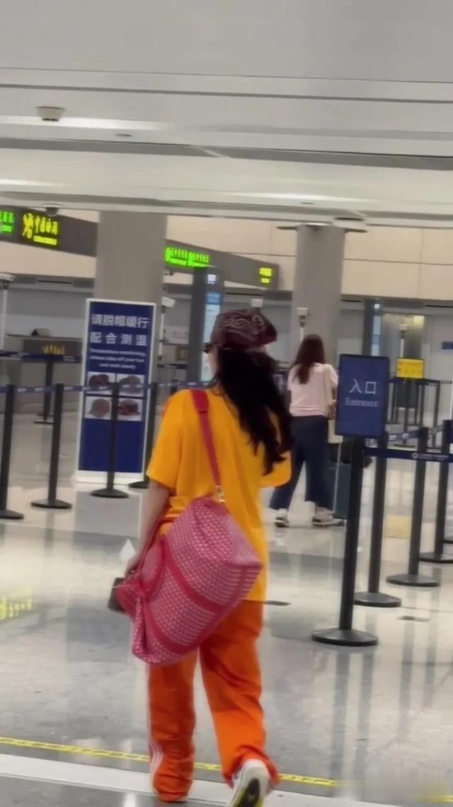 张柏芝机场过安检被偶遇，一身橙色运动装穿搭，戴咖色头巾好吸睛