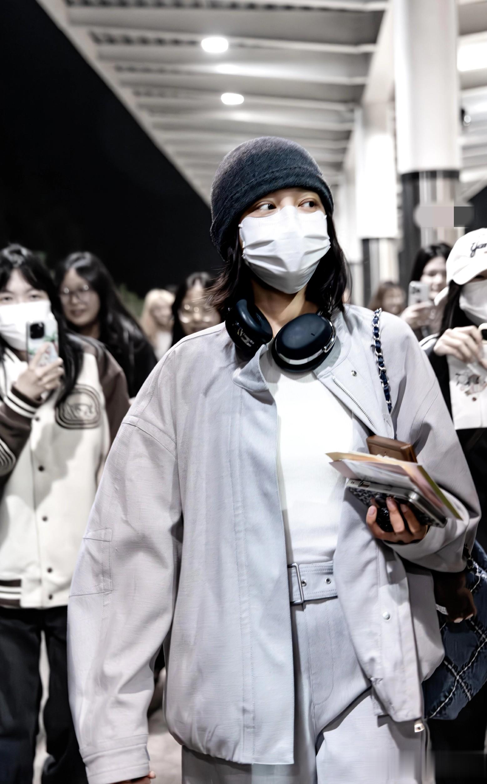 辛芷蕾平遥到达路透照,穿天蓝色皮衣套装戴着耳机 素颜出行接地气