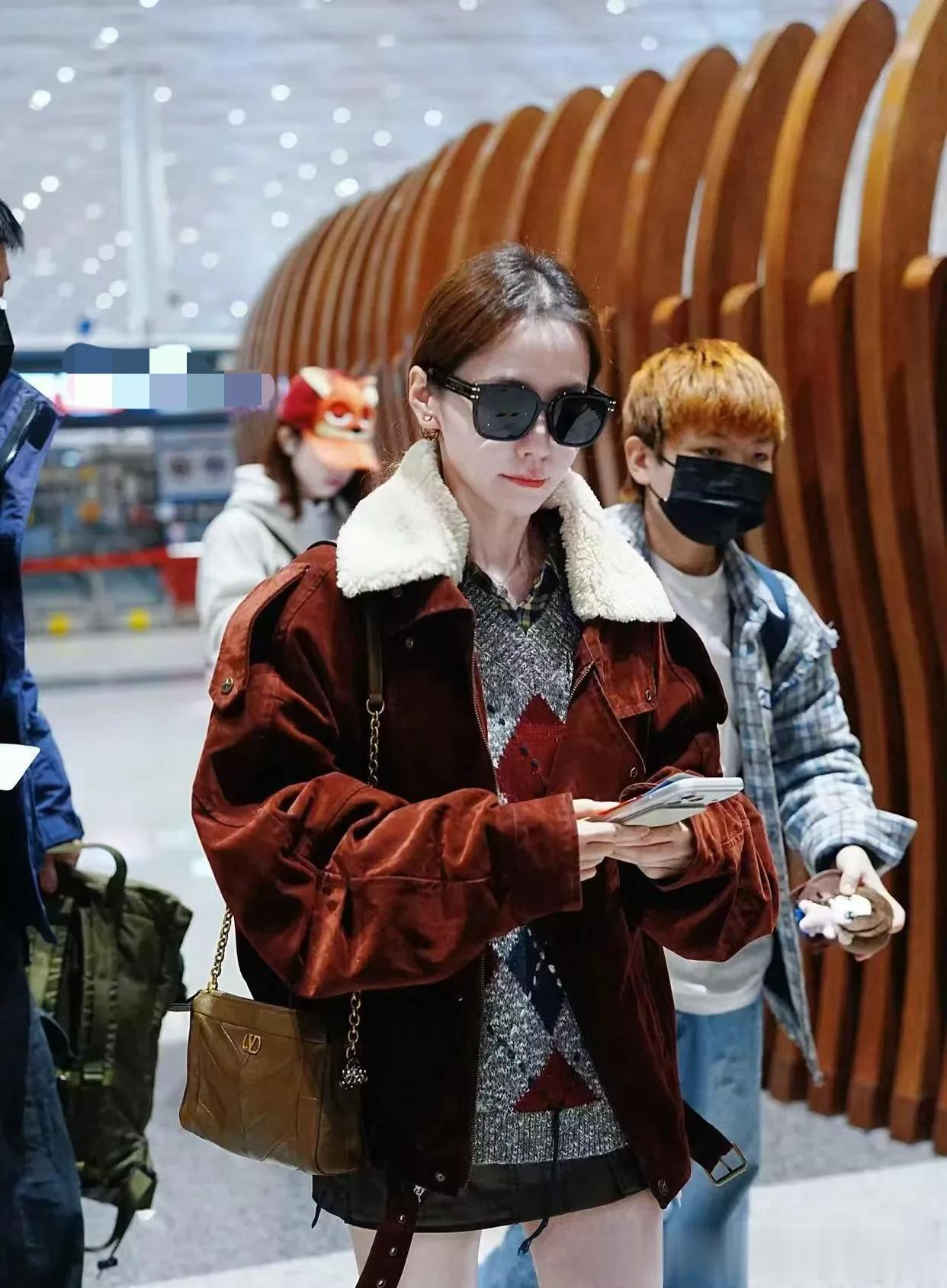 张靓颖机场私服真时髦！毛领夹克+短裙+长筒靴，洋气又高级！