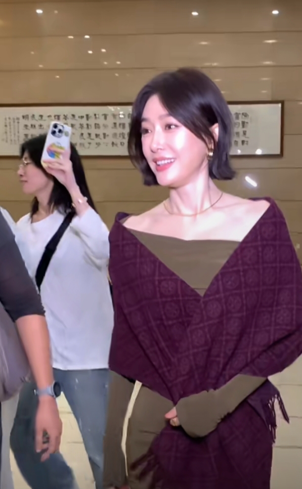 秦岚抵达广州出席活动，墨绿长裙搭酒红披巾，短发超有韵味