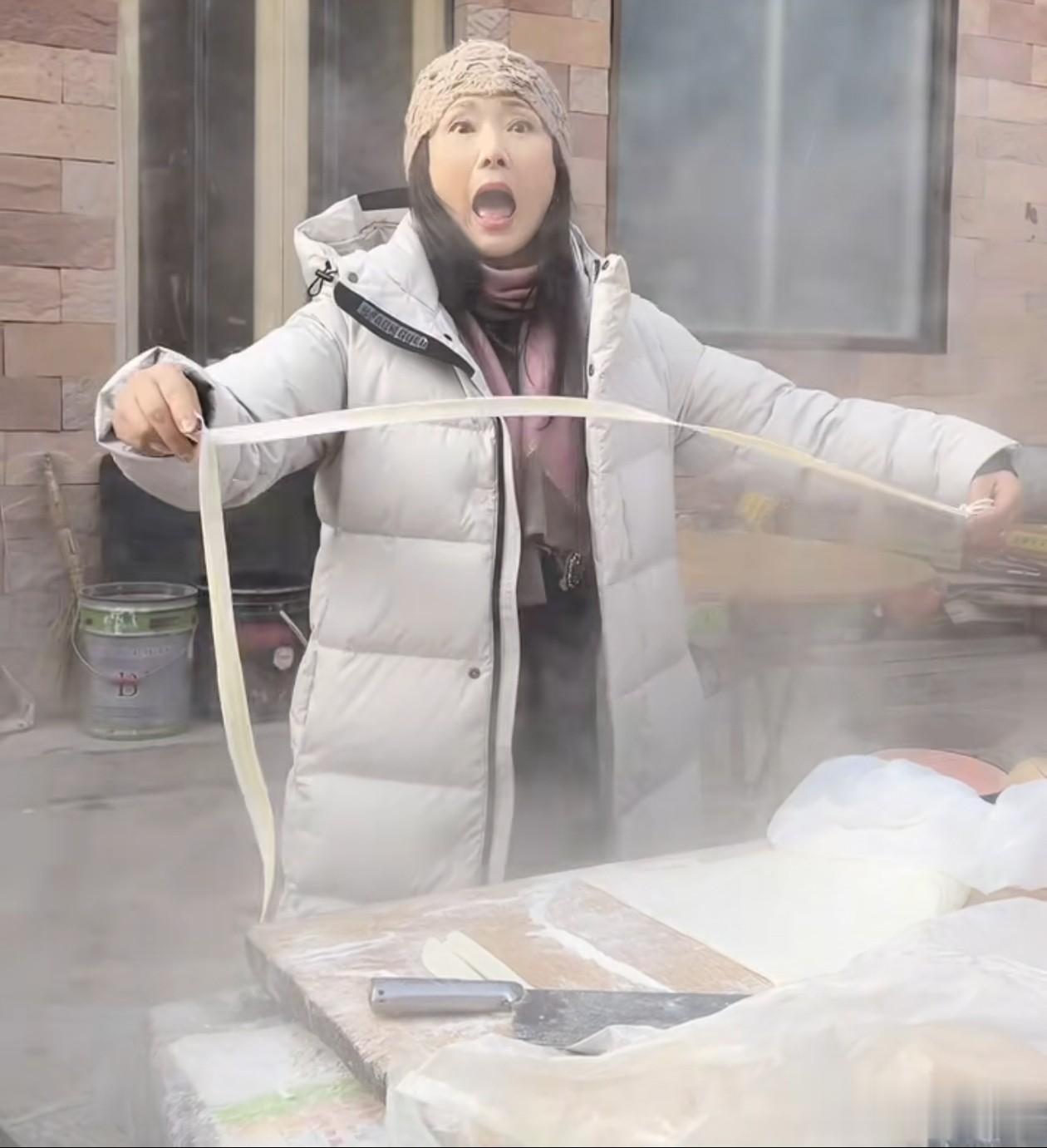 62岁何赛飞冬日穿搭：针织帽+羽绒服，双手拽面好接地气，像42岁