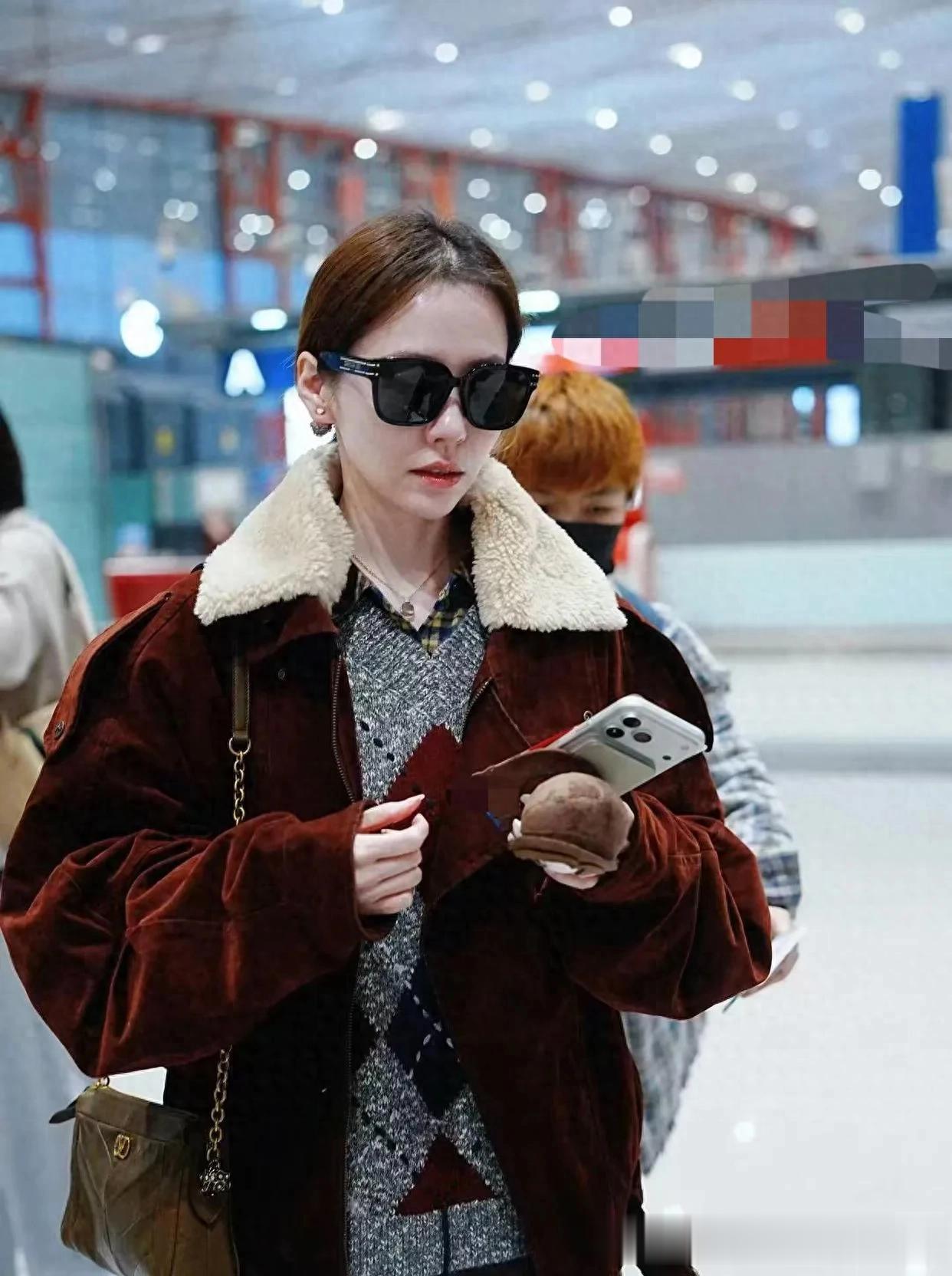 张靓颖机场私服真时髦！毛领夹克+短裙+长筒靴，洋气又高级！