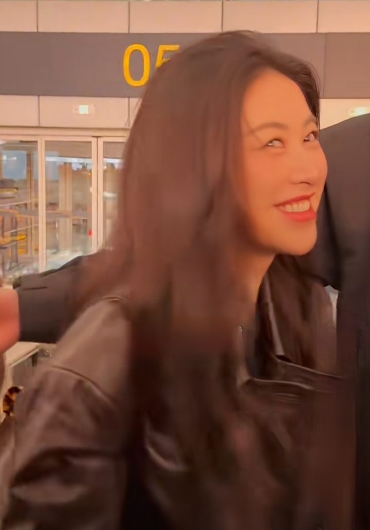 朱珠重庆机场出发，棕皮夹克搭长裤，波浪长发又飒又美