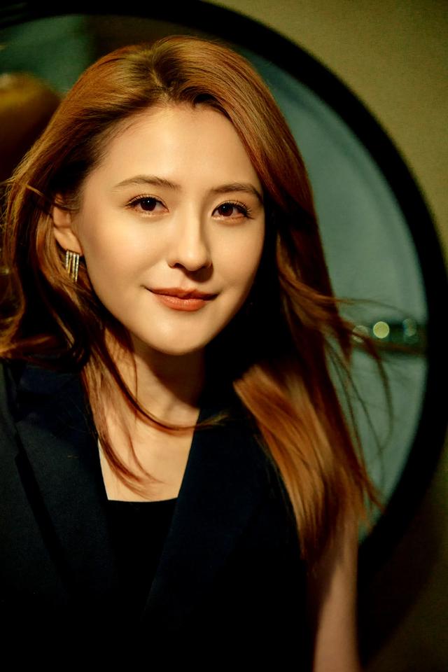 热依扎,一身气质职业套装,又美又大气,站在台上眼神温柔有内涵