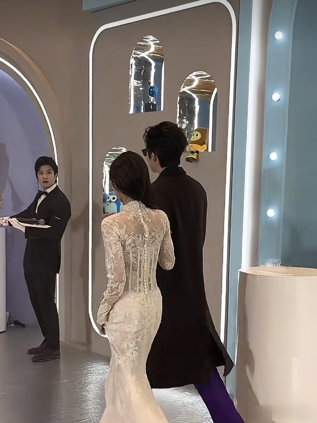 李一桐一袭白色长裙，优雅动人。二人挽手同行