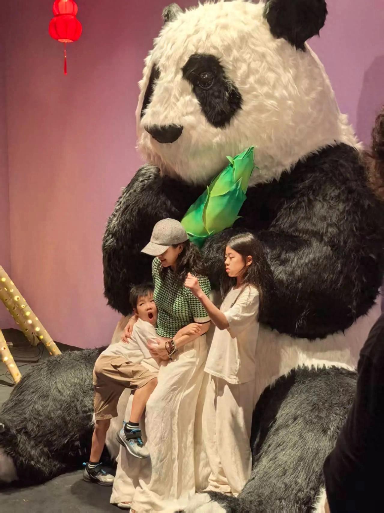 章子怡和两个孩子看熊猫,她抱着醒醒转圈很有爱,小儿子正脸像她
