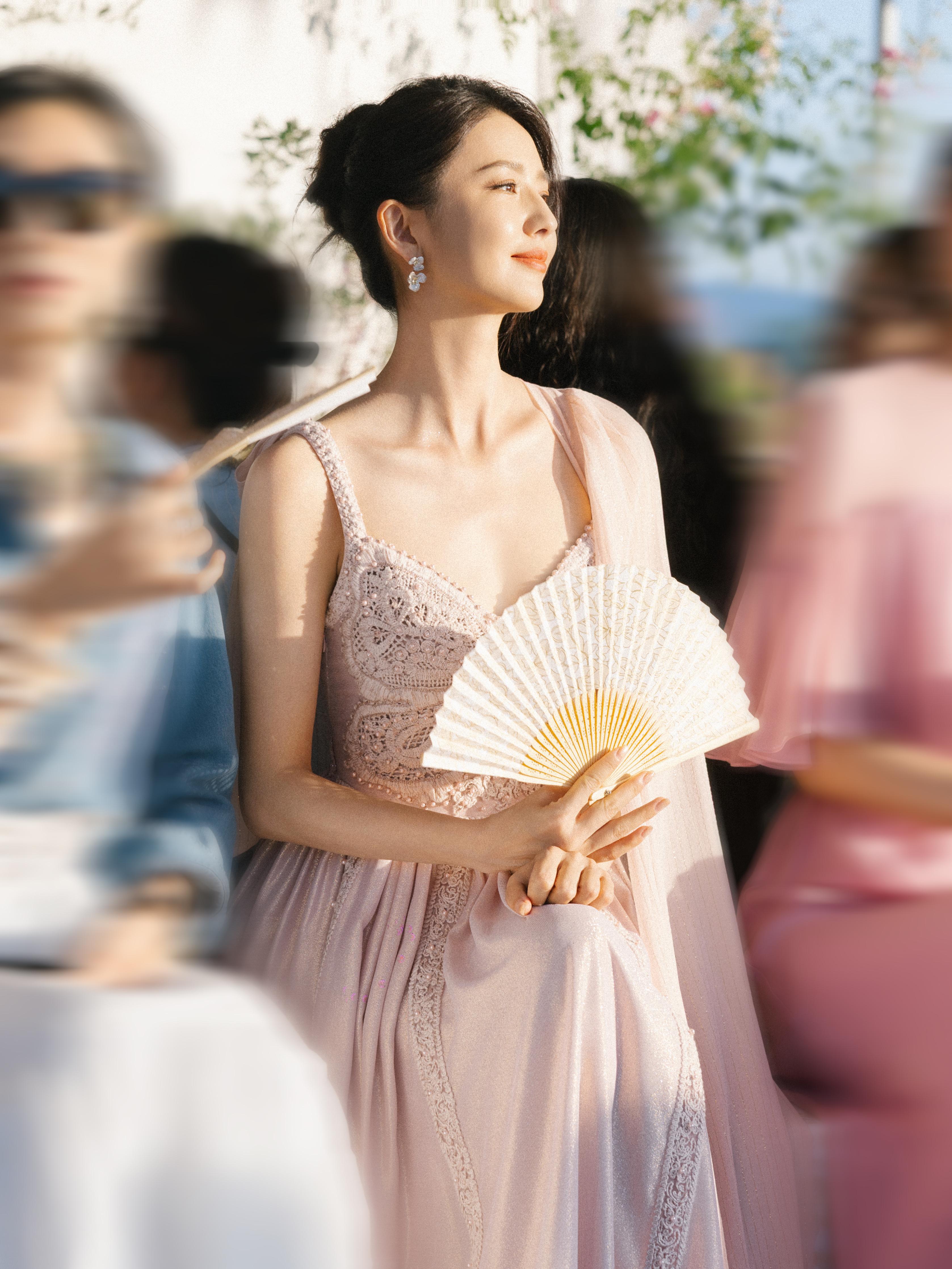 佟丽娅出席活动,身穿藕粉长裙,折扇轻扇,优雅美丽