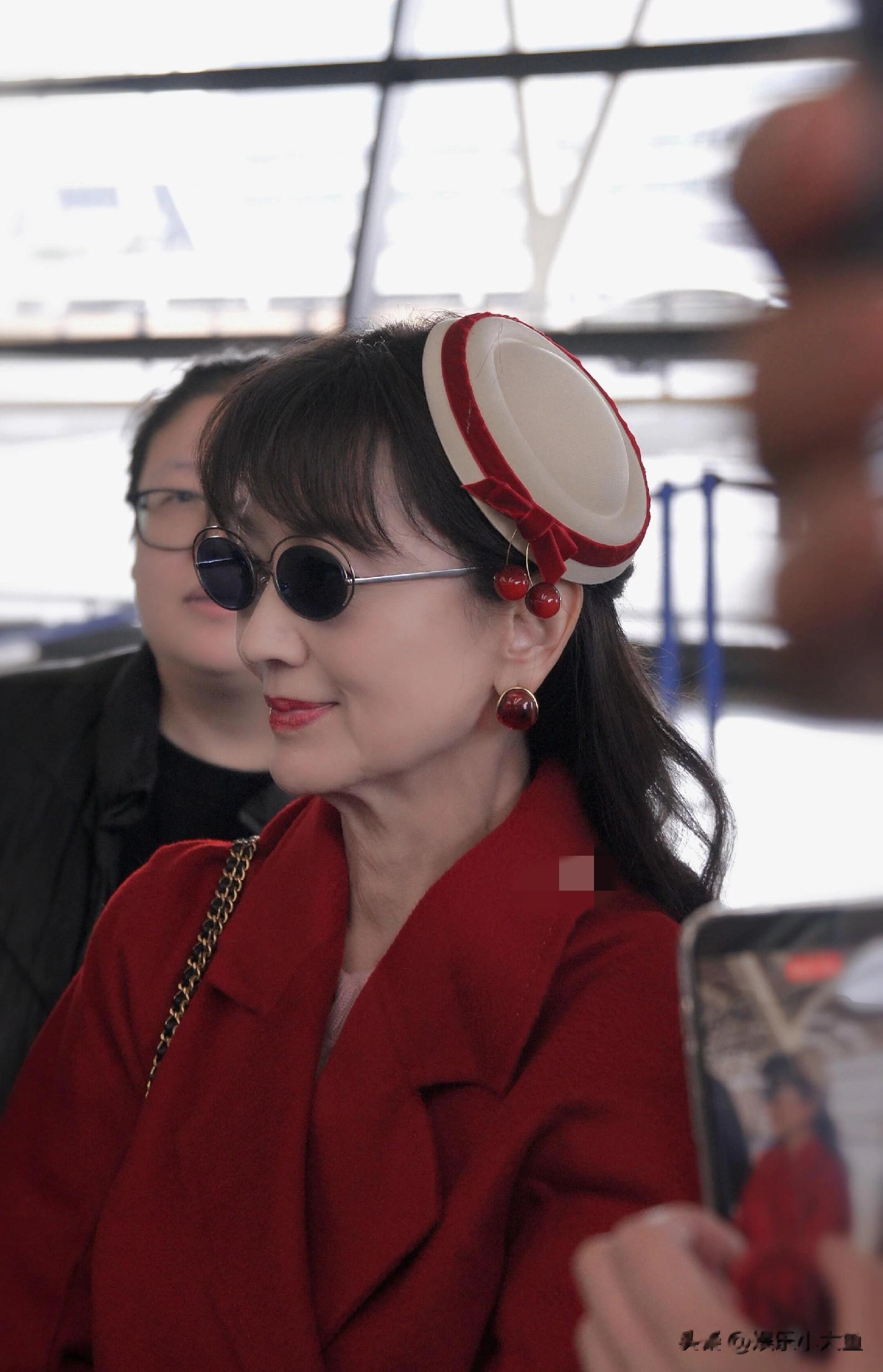 赵雅芝上海出发机场路透，穿红色长款大衣戴贝雷帽，喜庆又洋气