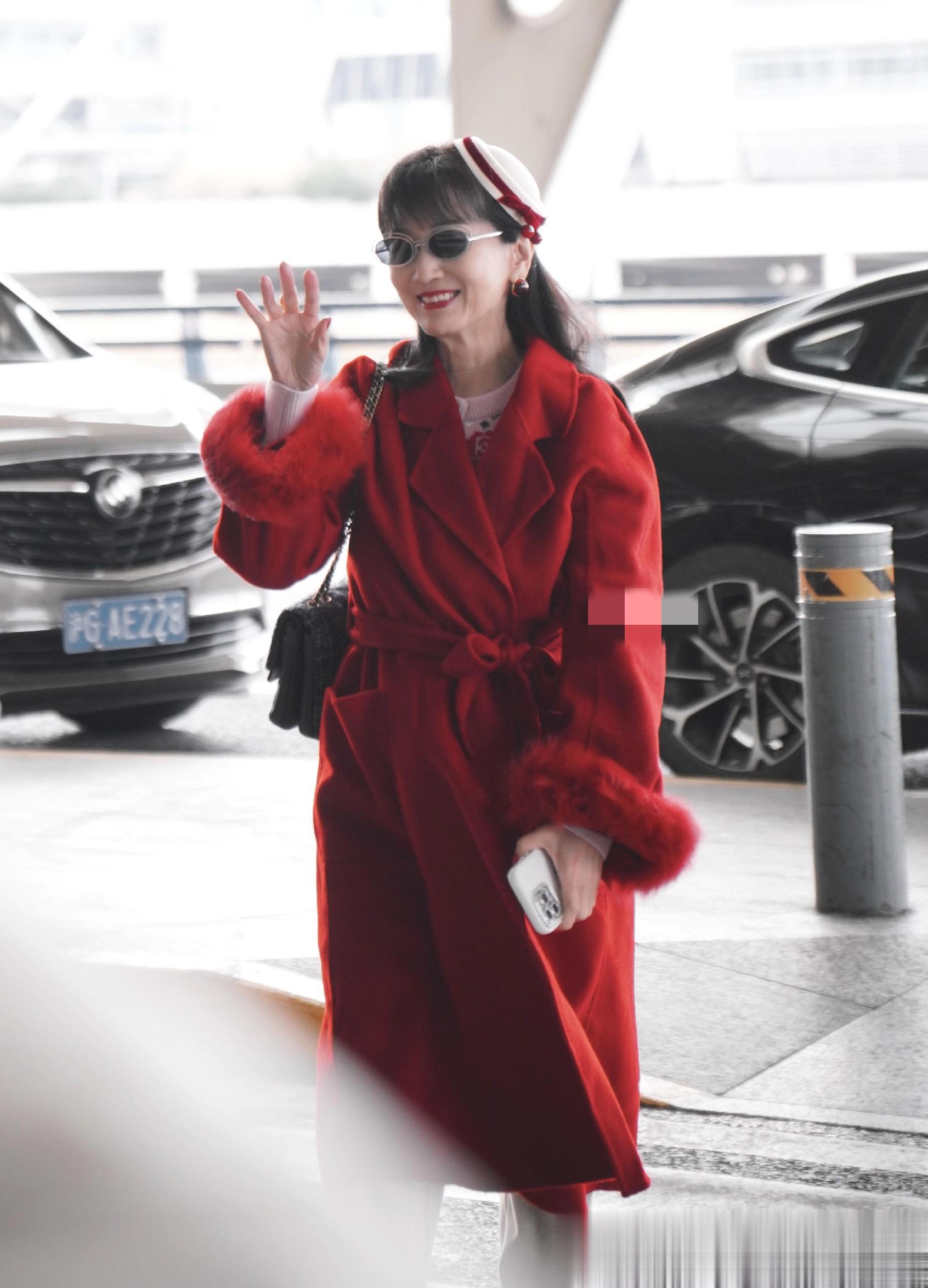 赵雅芝上海出发机场路透，穿红色长款大衣戴贝雷帽，喜庆又洋气