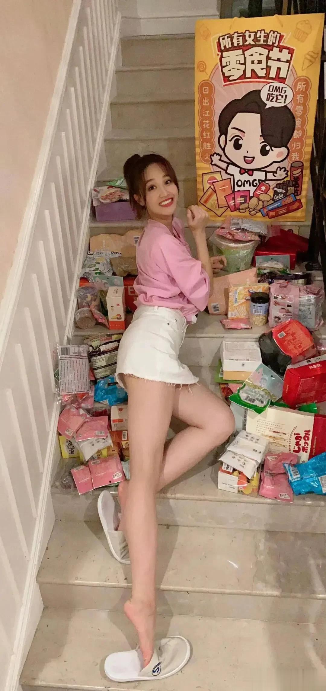 零食堆里的蓝盈莹好可爱，粉衣白短裤秀出超长腿