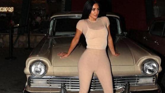 44岁金·卡戴珊穿薄款肤色塑身衣躺车上，撩黑发，三个孩子在旁边