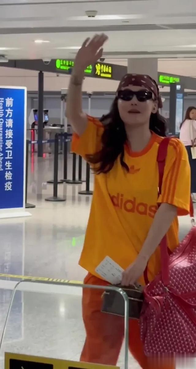 张柏芝机场过安检被偶遇，一身橙色运动装穿搭，戴咖色头巾好吸睛
