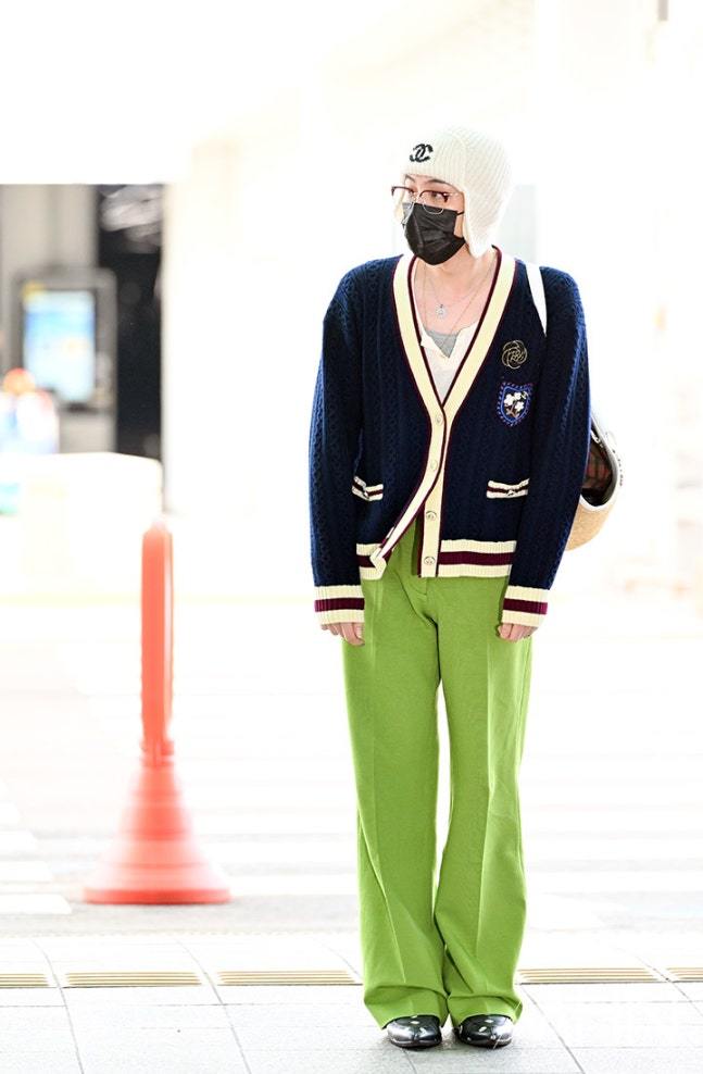 权志龙穿蓝色针织开衫，戴白色无檐帽，荧光绿阔腿裤吸睛