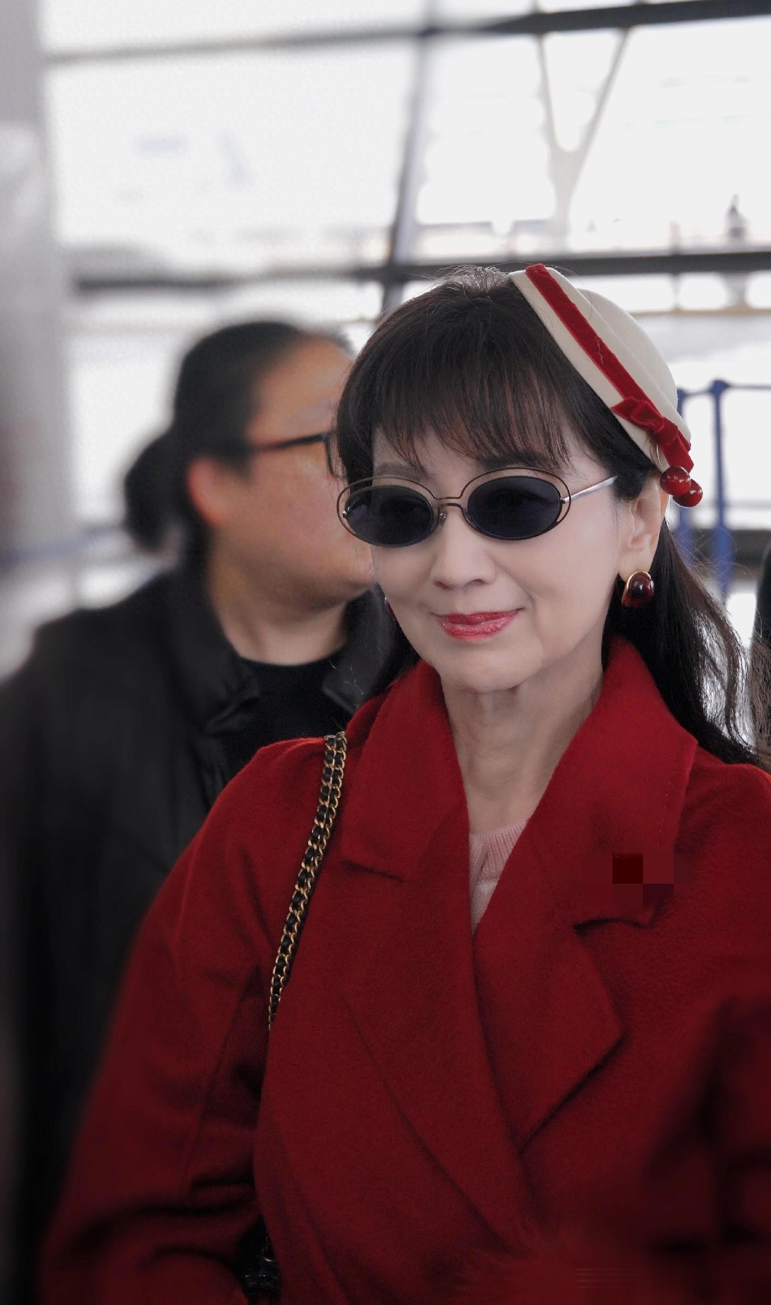 赵雅芝上海出发机场路透，穿红色长款大衣戴贝雷帽，喜庆又洋气