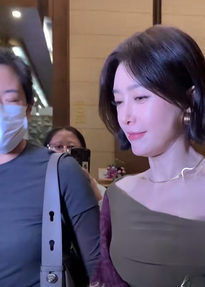 秦岚抵达广州出席活动，墨绿长裙搭酒红披巾，短发超有韵味