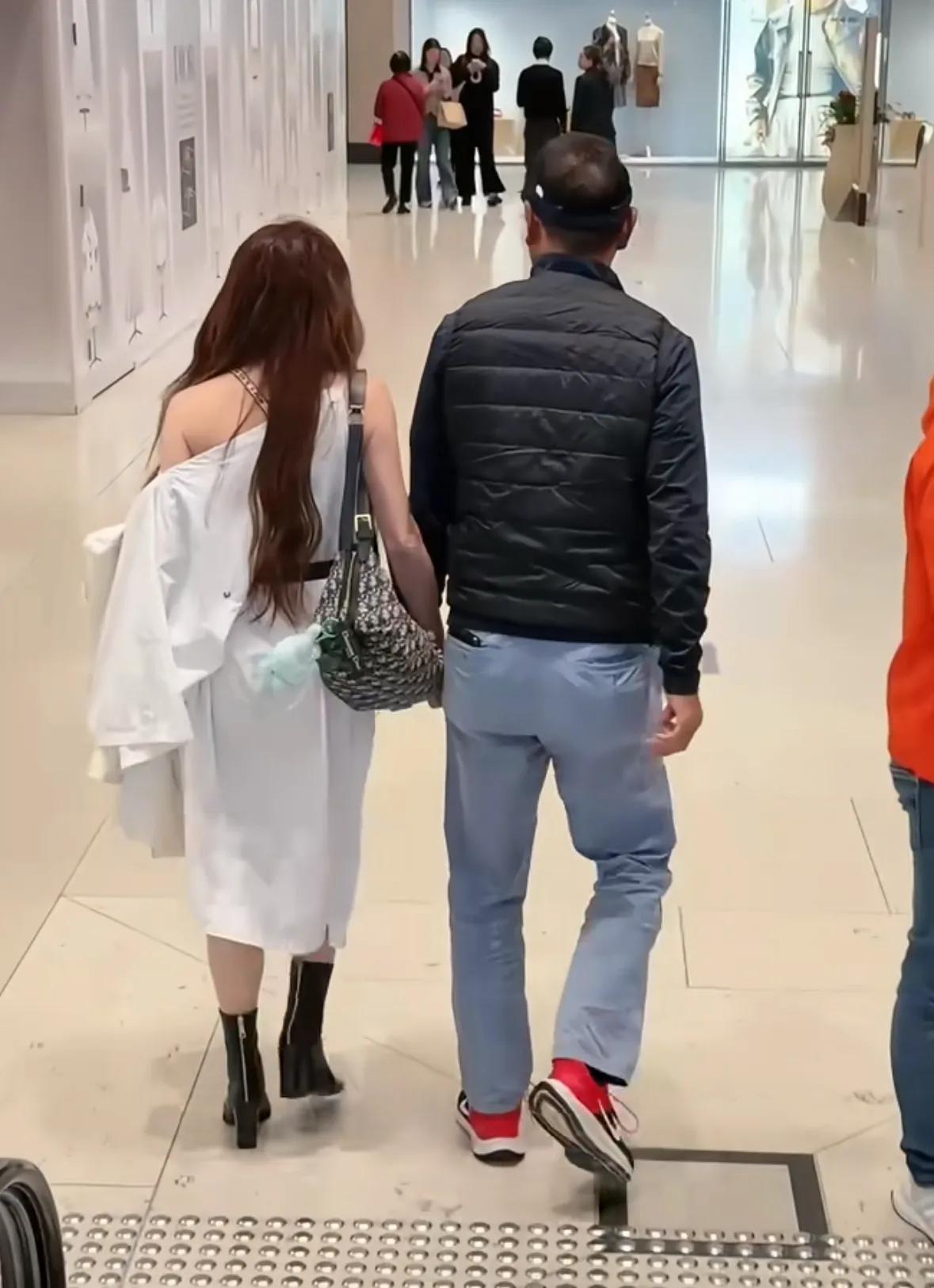 温碧霞和老公出街，天气冷还穿着露胳膊的衣服，发型也是一成不变