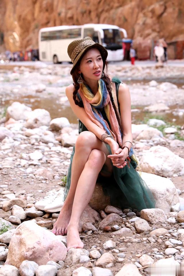 林志玲光脚坐在野外石头上，始终保持微笑，太有敬业精神