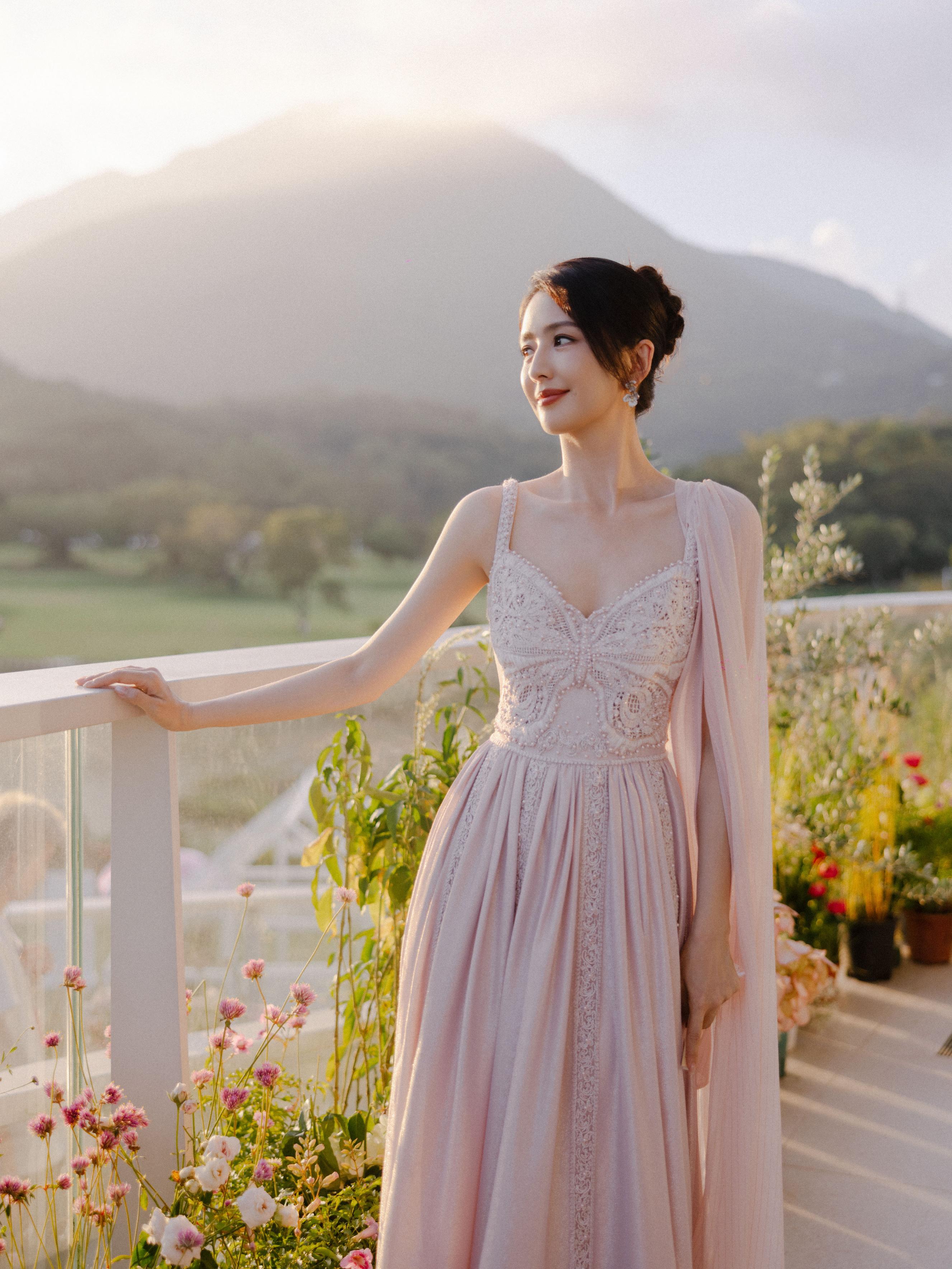 佟丽娅出席活动,身穿藕粉长裙,折扇轻扇,优雅美丽