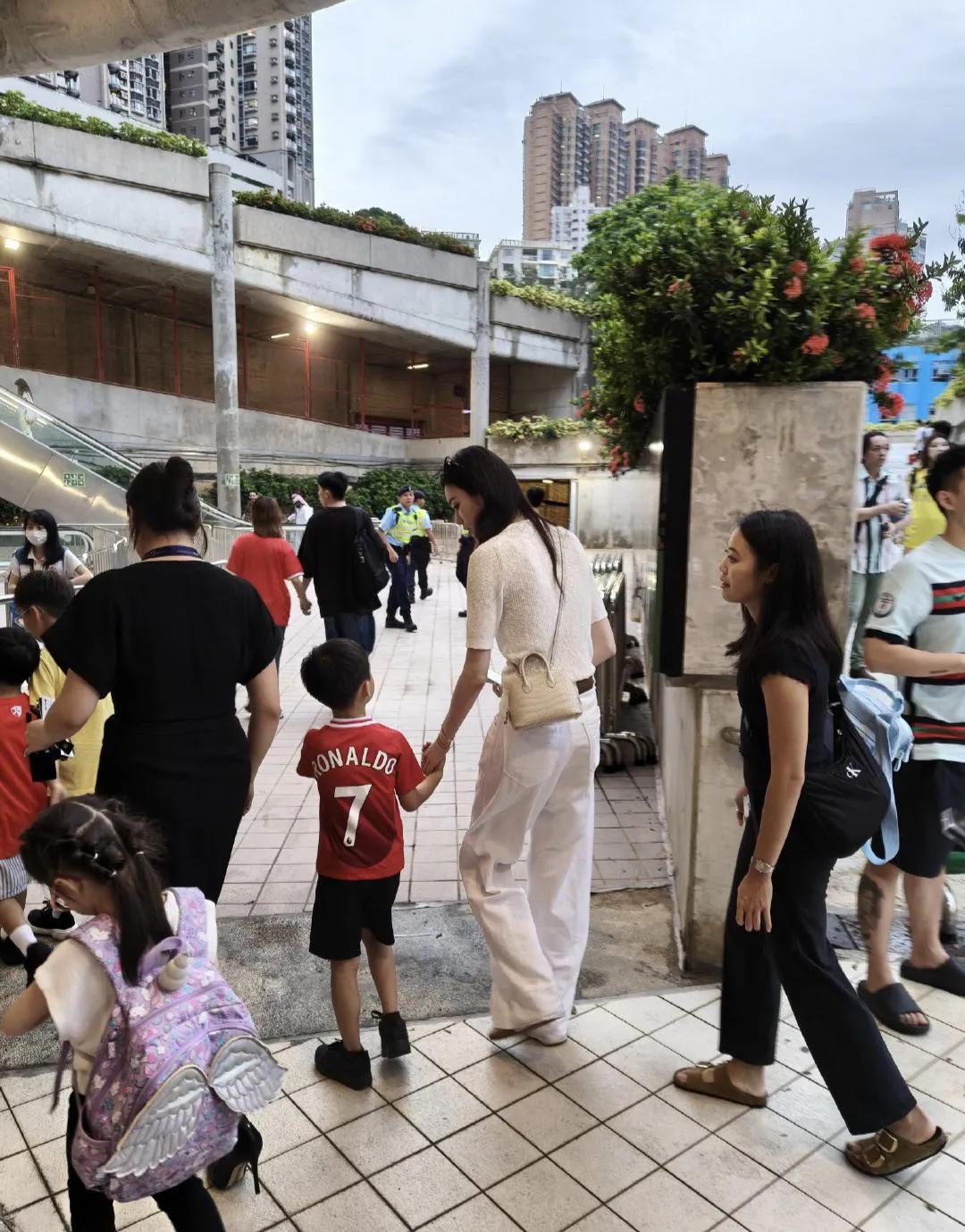 奚梦瑶带5岁儿子看球赛，蹲着帮儿子整理仪容，两人牵着手好有爱
