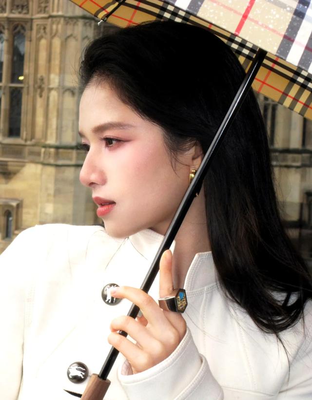 张婧仪前往巴黎时装周,雨天拍片,一把格子伞拿捏氛围感