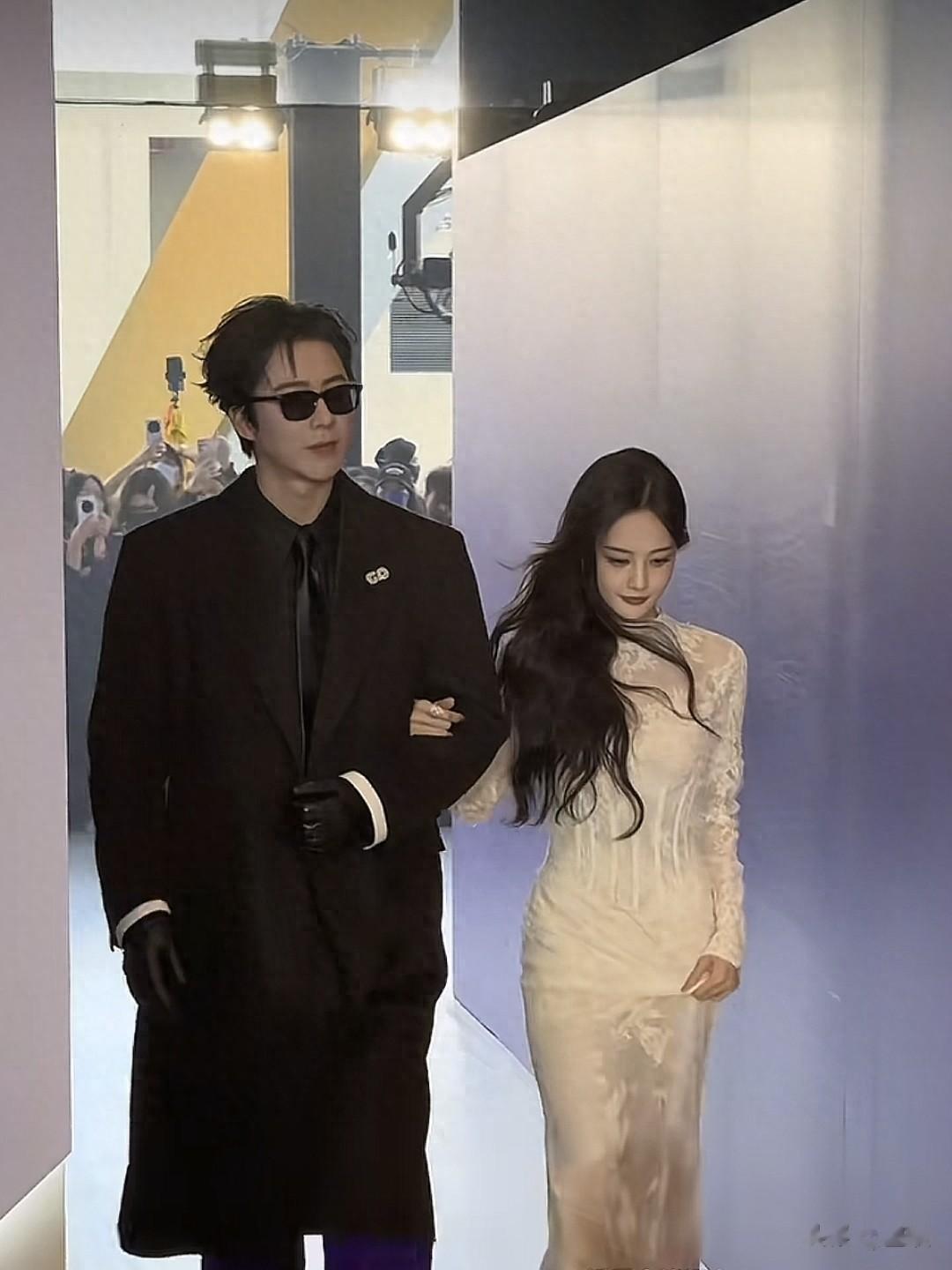 李一桐一袭白色长裙，优雅动人。二人挽手同行