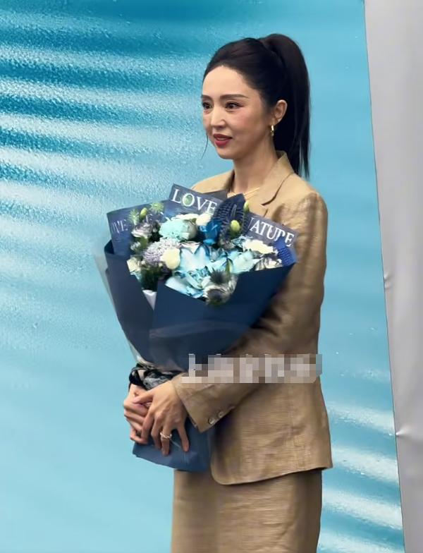 46岁董璇上海参加活动,脸僵褶子多有了孕味,拿花遮小腹一脸尴尬