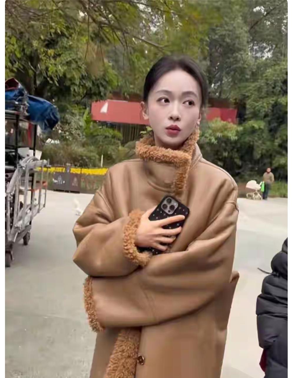 吴谨言一身卡其色大衣，衬托出苗条的身材，扎着高马尾，显年轻。