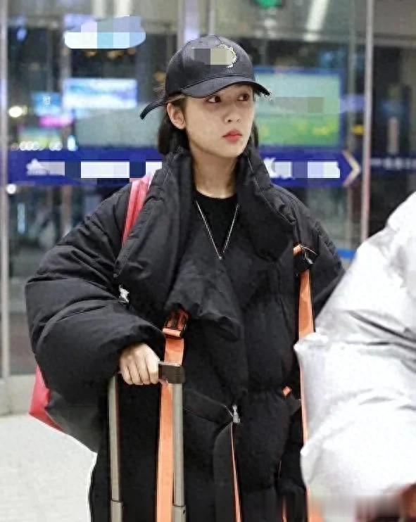 杨紫机场私服真时髦！穿黑色羽绒服+红色运动裤，戴棒球帽好减龄