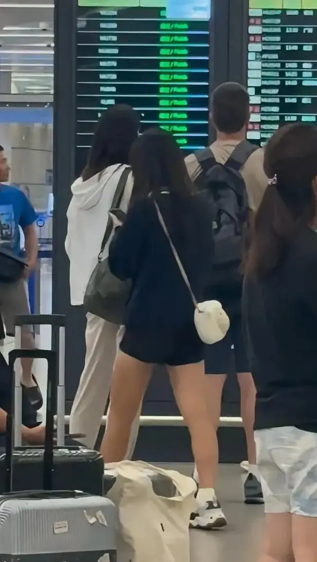 森碟独自现身机场，低头玩手机，背部又壮又宽，一双腿也很粗