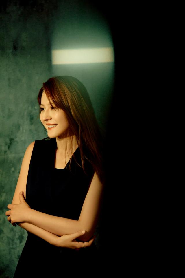 热依扎,一身气质职业套装,又美又大气,站在台上眼神温柔有内涵