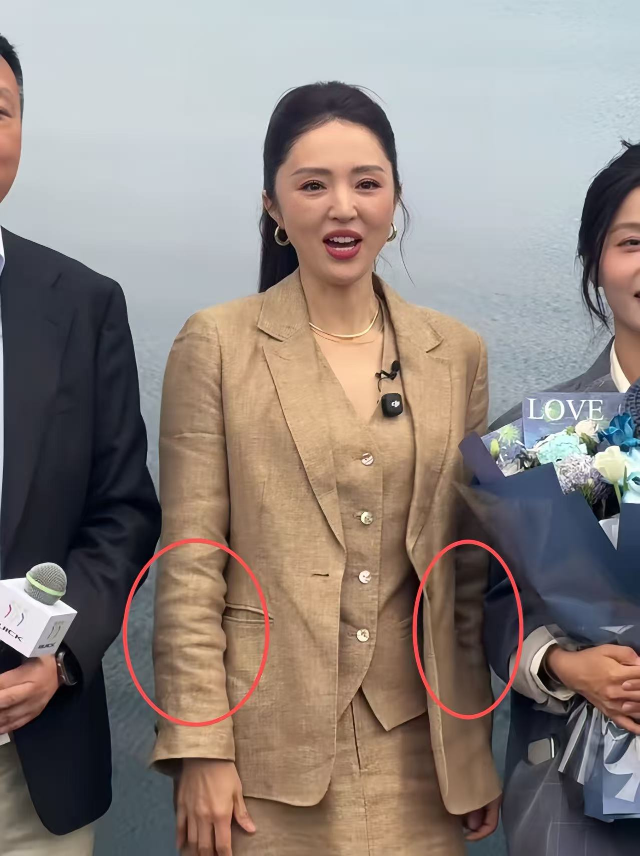 46岁董璇上海参加活动,脸僵褶子多有了孕味,拿花遮小腹一脸尴尬