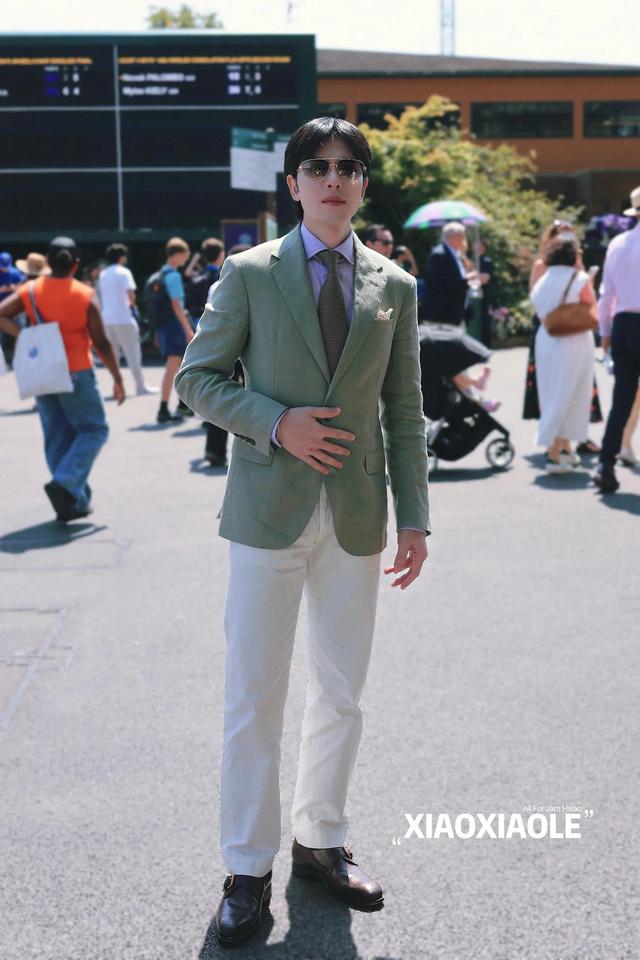 萧敬腾和林有慧牵手看温网,萧敬腾穿绿色西装很帅,他俩长得很像