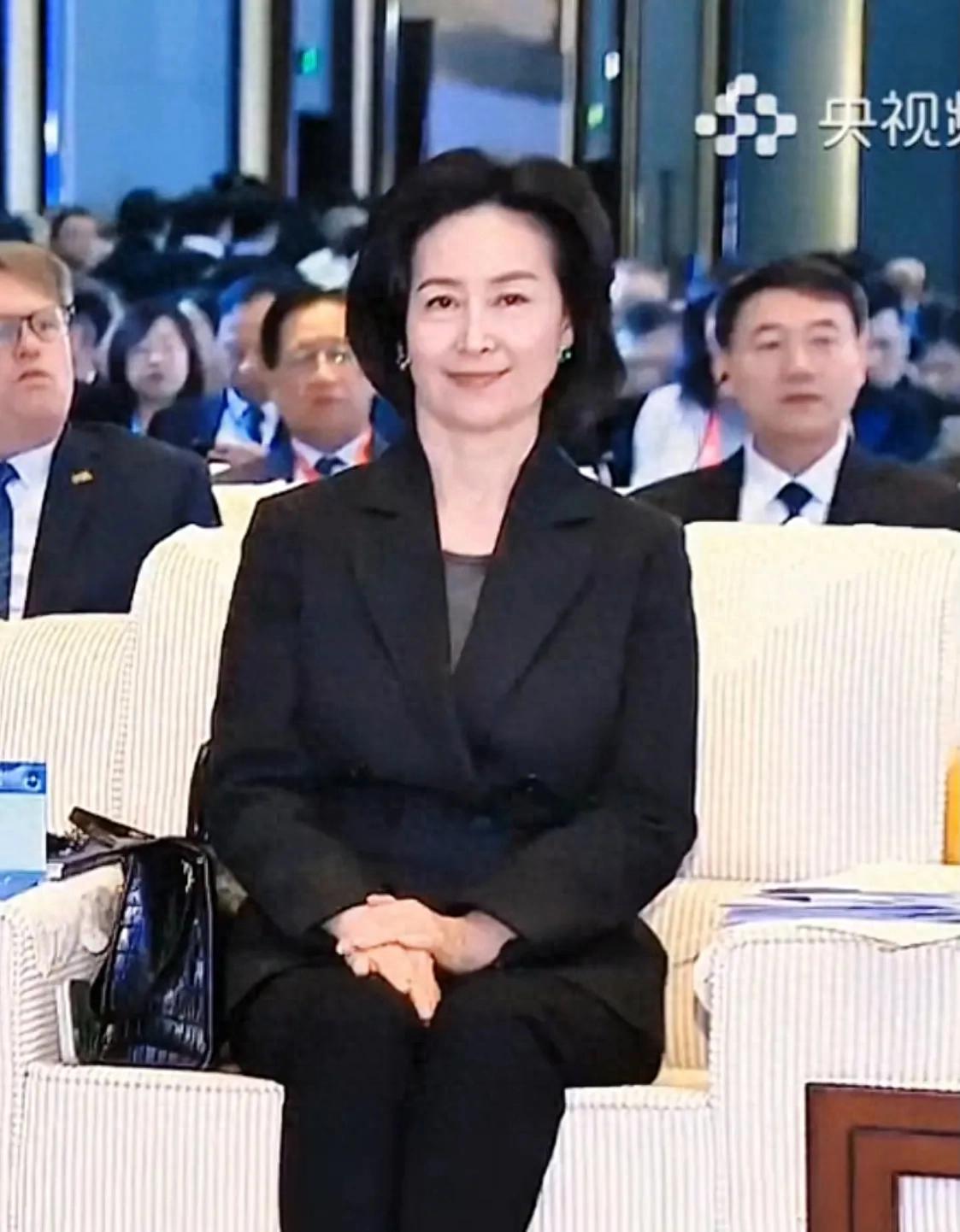 何超琼出现在新闻联播上，她坐姿端正很大气，她穿毛毛领毛衣更美