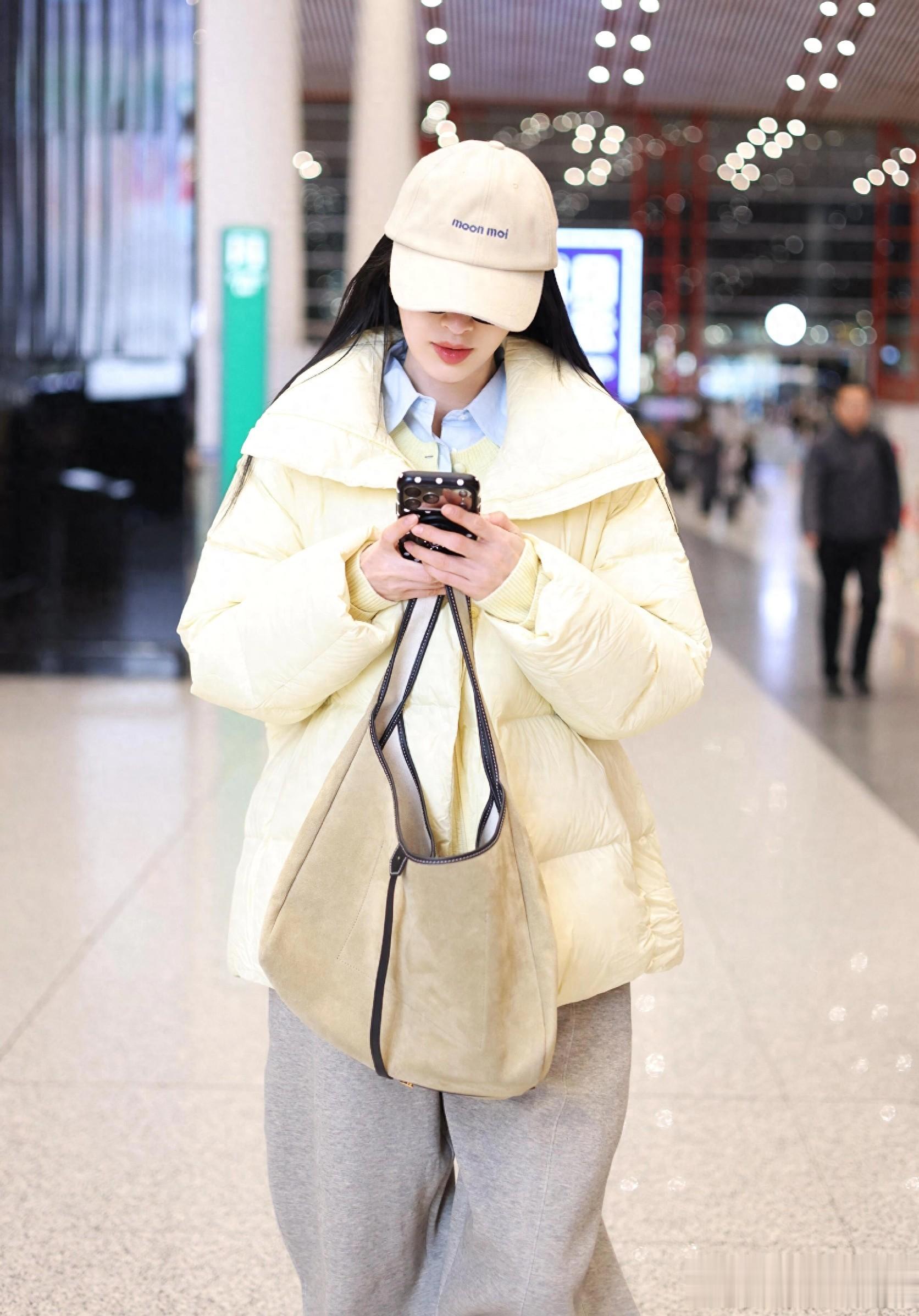 张俪最新机场美照，穿奶黄色羽绒服戴着墨镜，长发飘飘又美又温柔