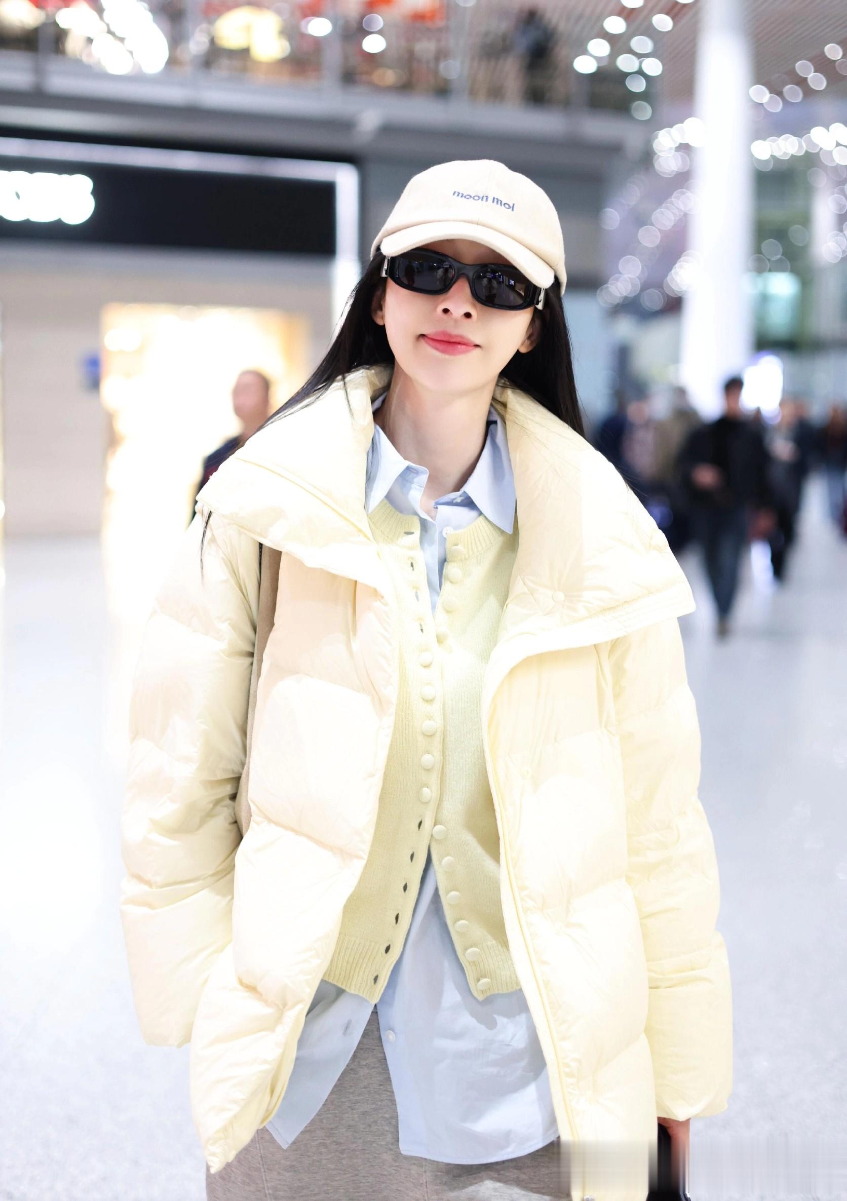 张俪最新机场美照，穿奶黄色羽绒服戴着墨镜，长发飘飘又美又温柔