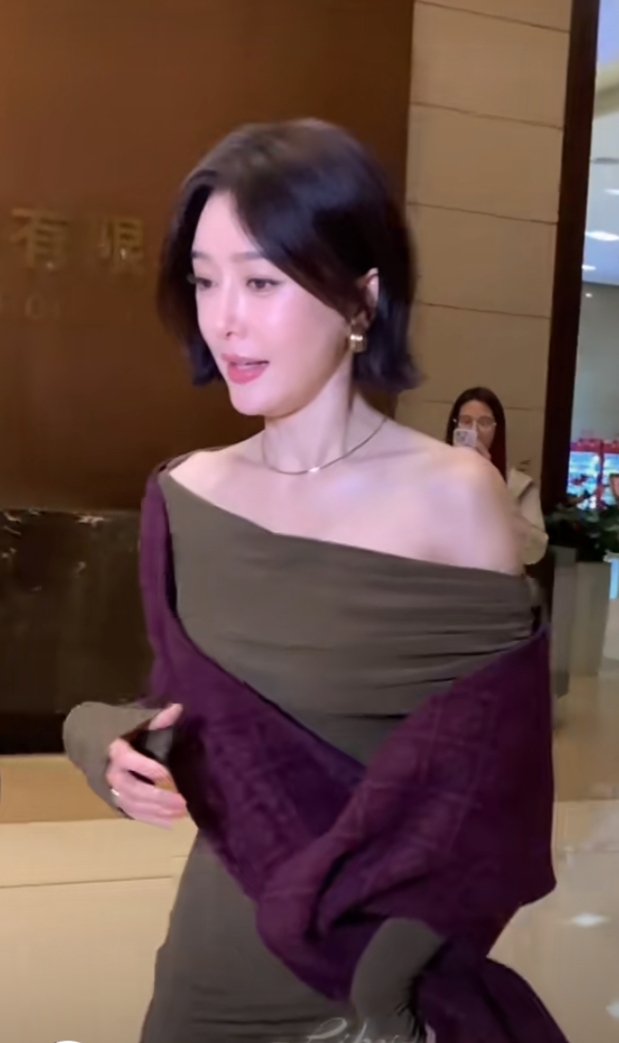 秦岚抵达广州出席活动，墨绿长裙搭酒红披巾，短发超有韵味