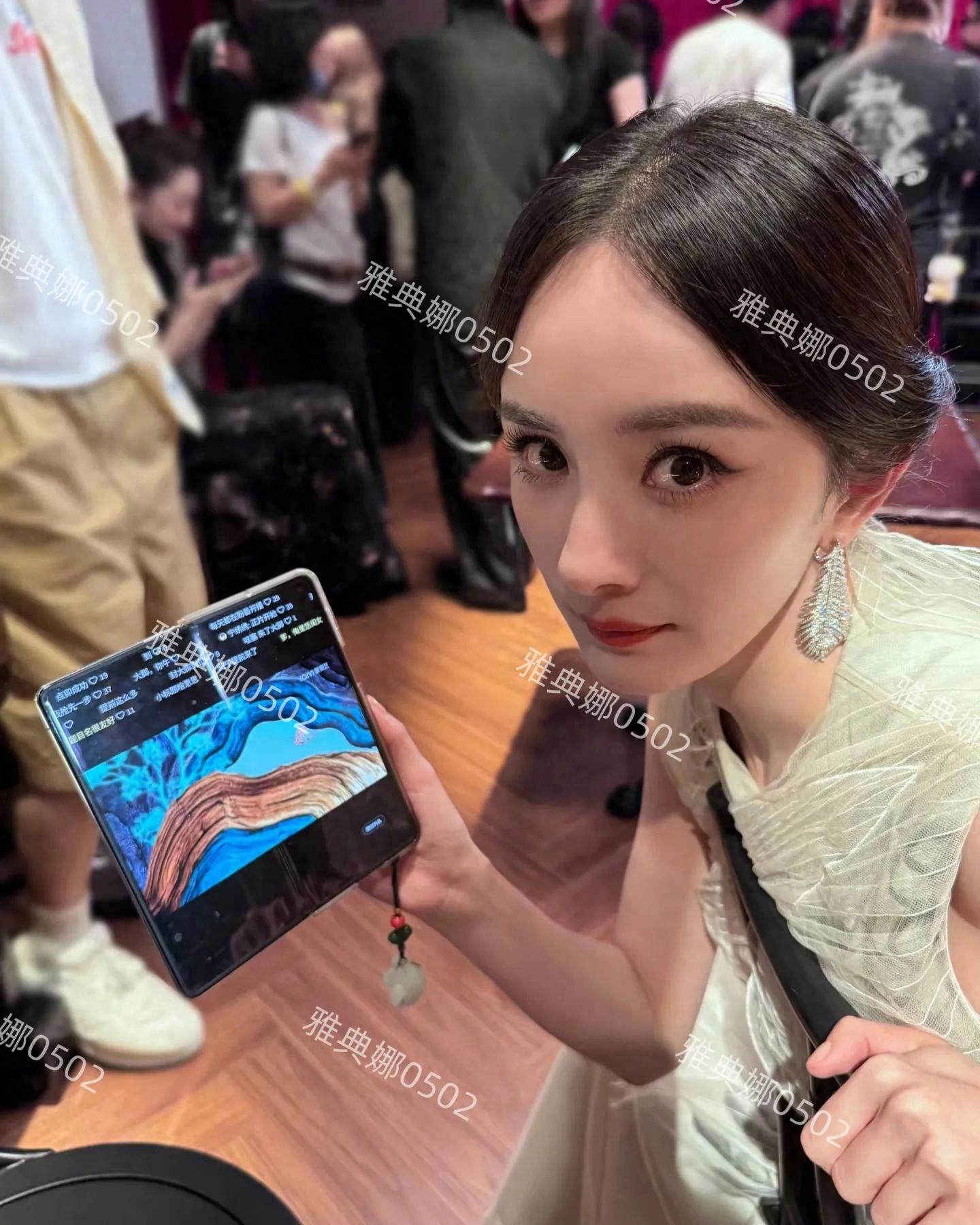 杨幂为了宣传新剧《生万物》真的很拼很用心，连红毯现场都在追剧