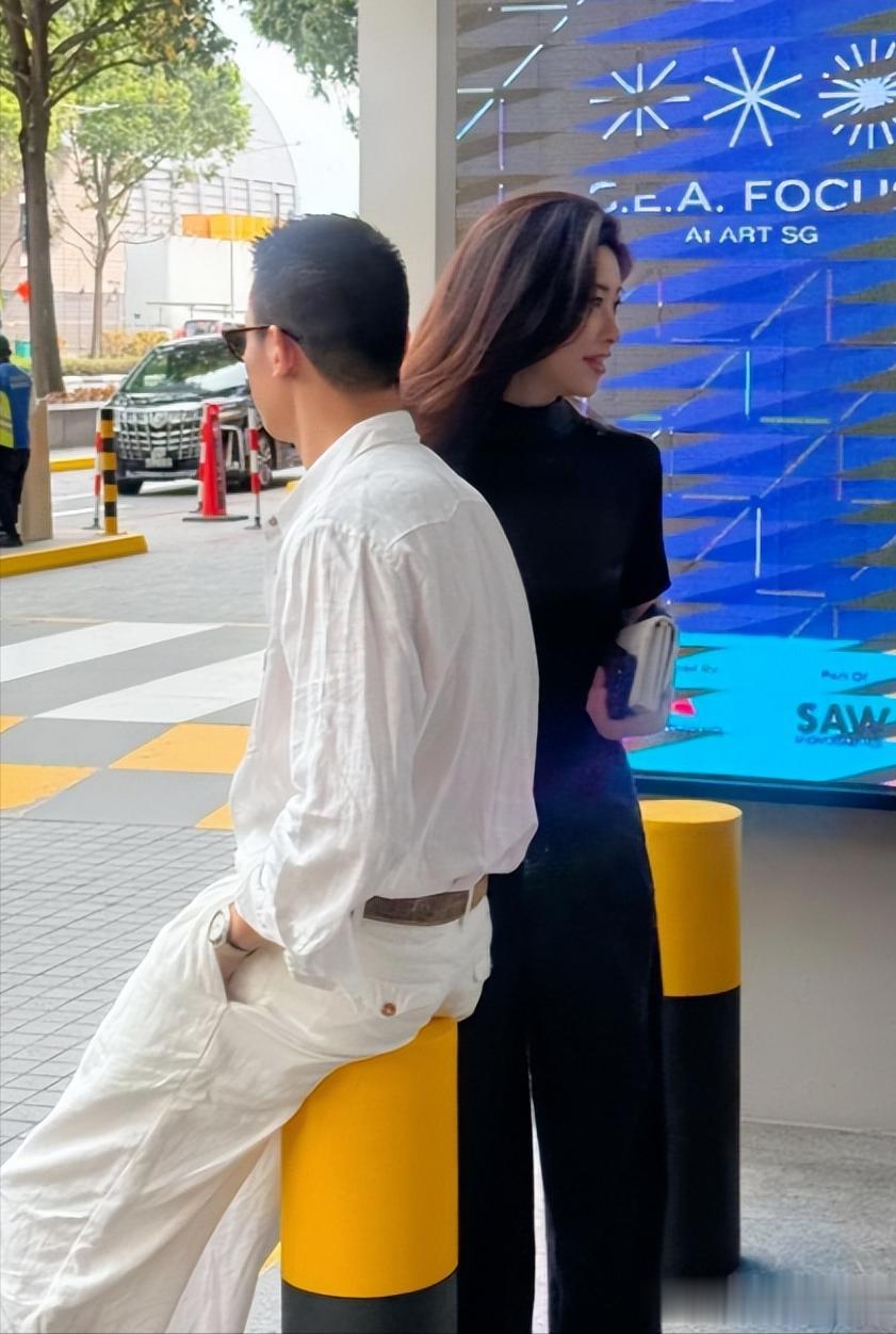 朱珠和老公在新加坡路边等车,她的老公身材高大,长相英俊。