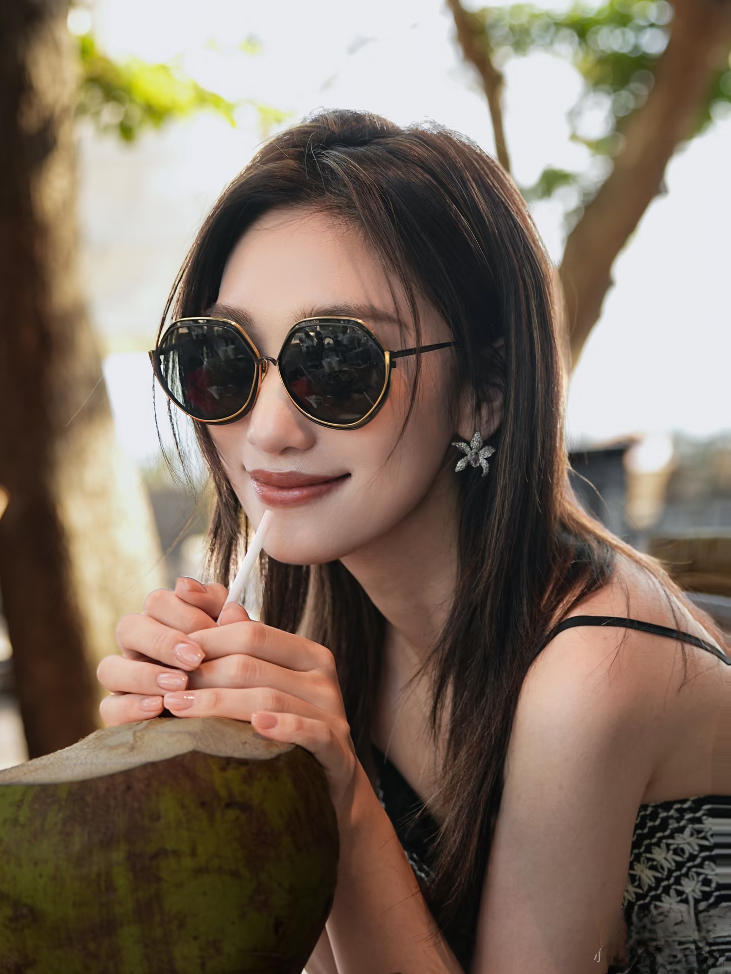 主持人蓝羽手捧椰汁拍美照，一袭吊带裙配长发，惬意又漂亮