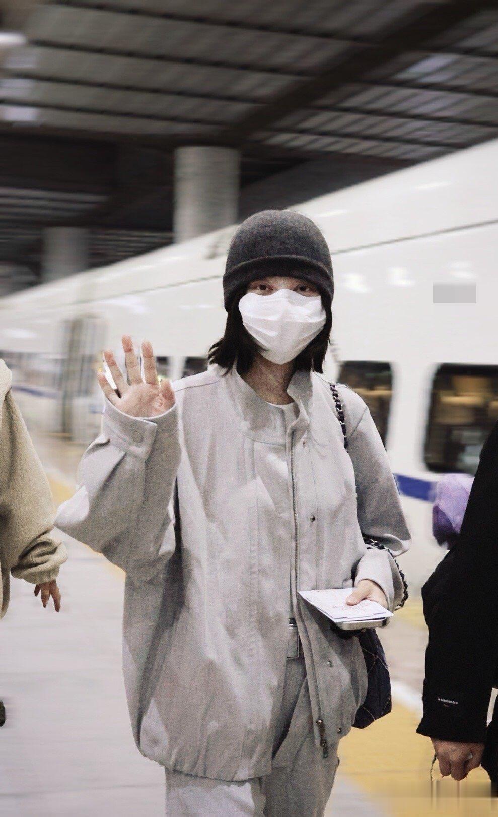 辛芷蕾平遥到达路透照,穿天蓝色皮衣套装戴着耳机 素颜出行接地气