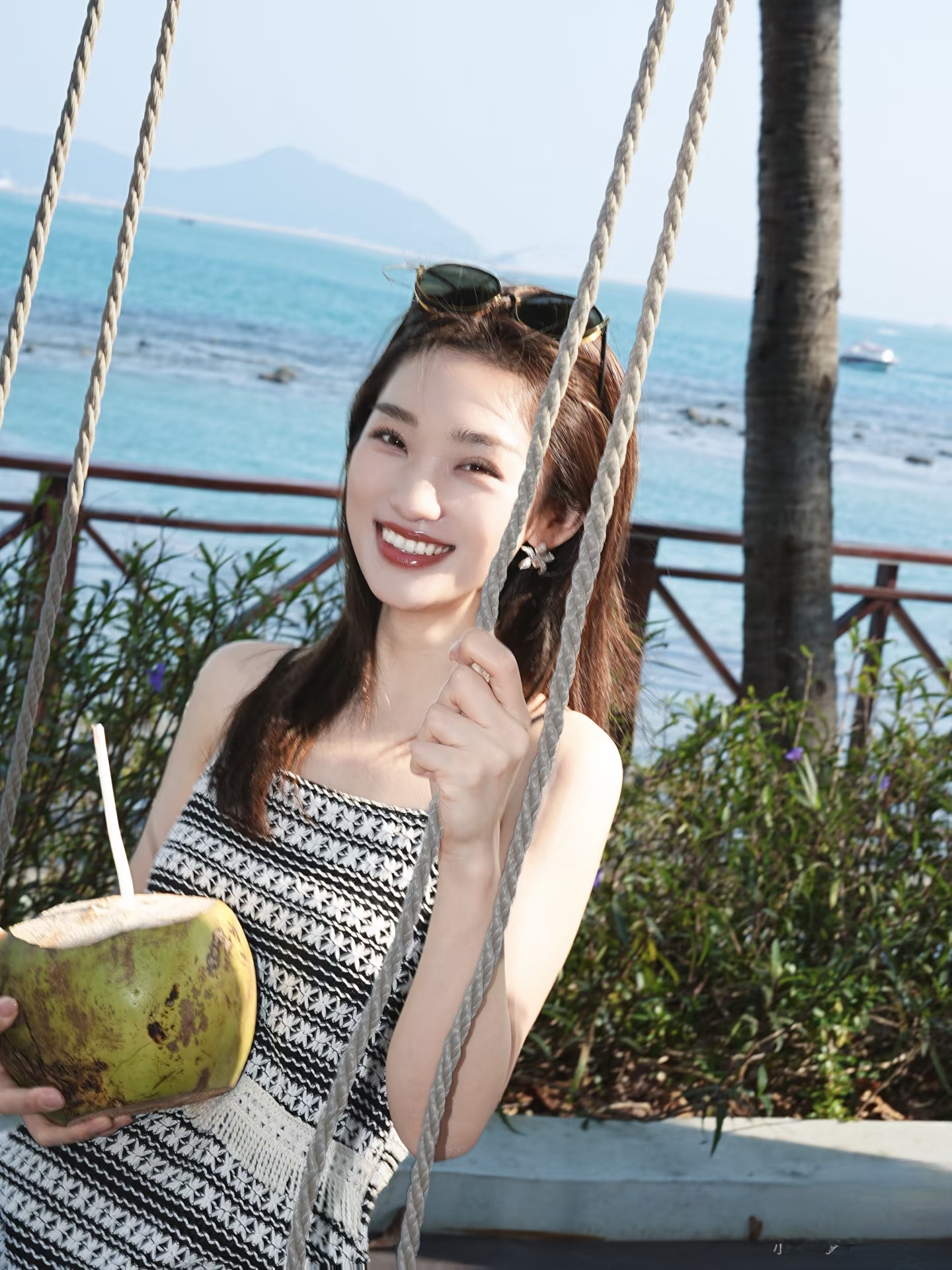 主持人蓝羽手捧椰汁拍美照，一袭吊带裙配长发，惬意又漂亮