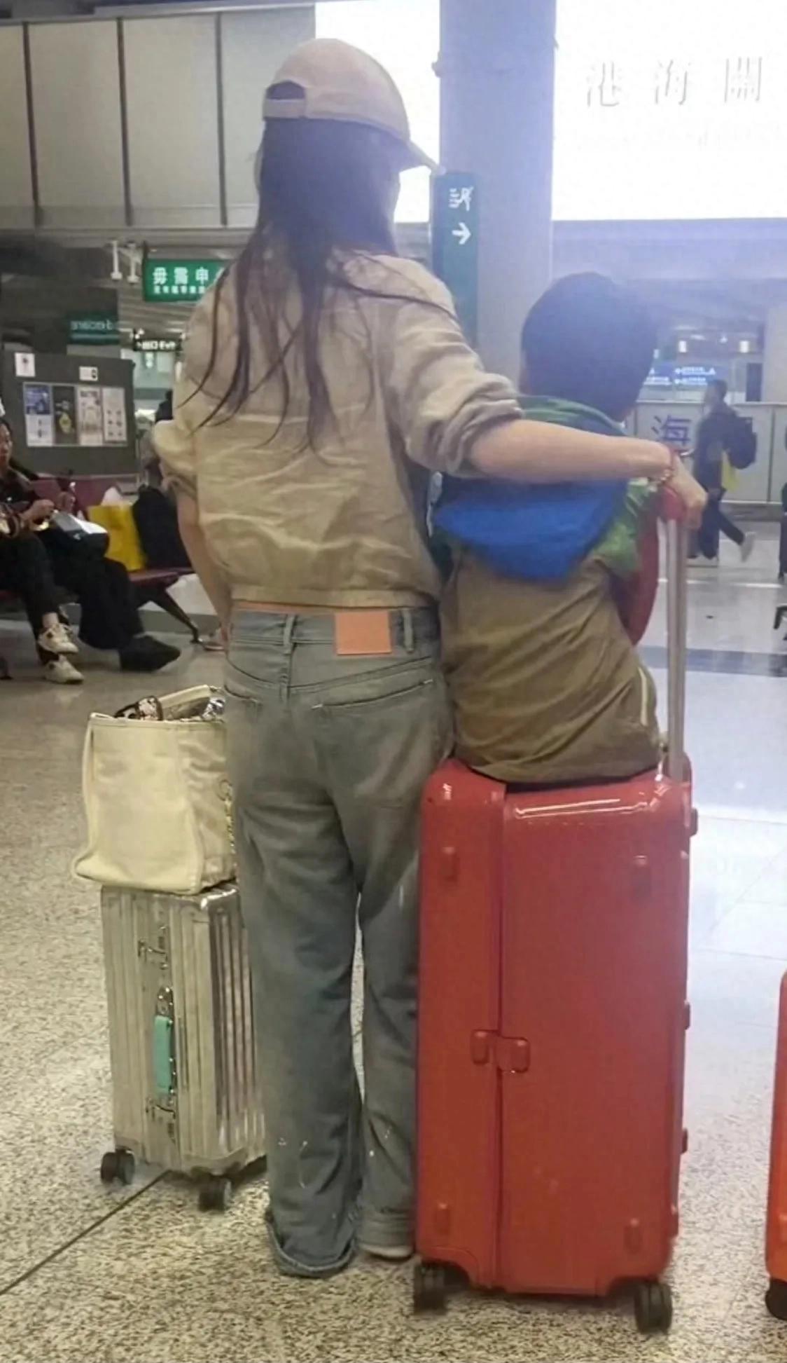 杨颖独自带着儿子回香港,自己抬行李箱,裤脚踩脚底下,狼狈极了