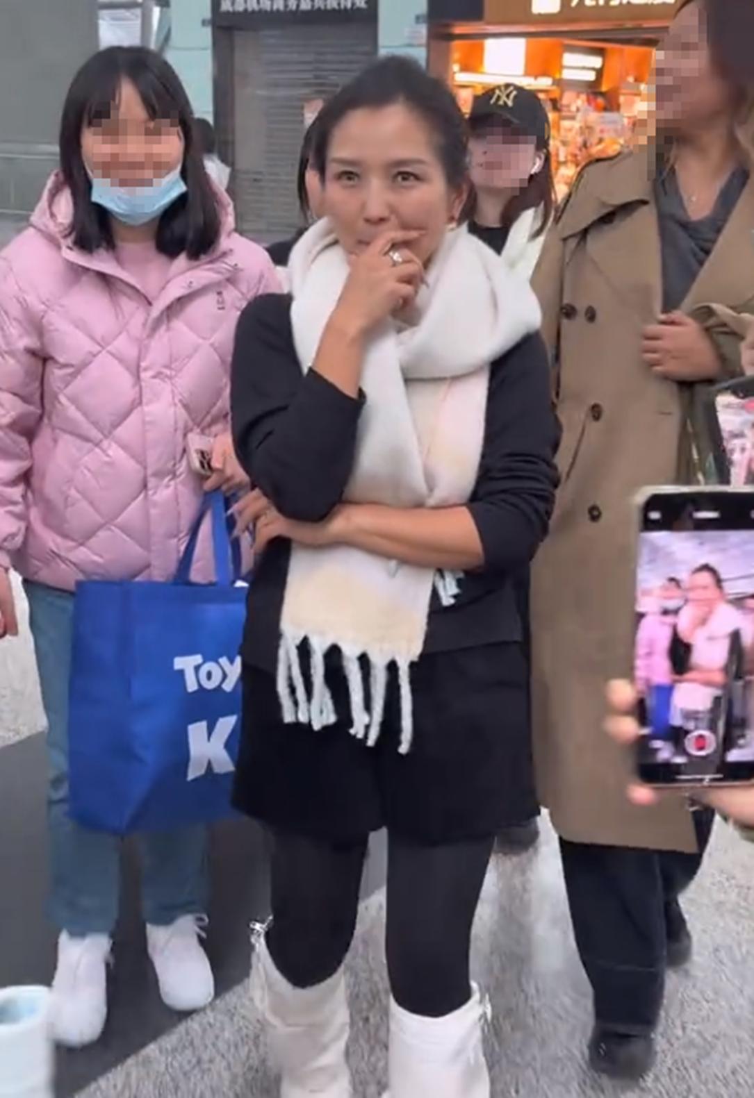 何洁现身机场，穿衣打扮保持20年前审美，素颜黑又显老撞脸郑佩佩