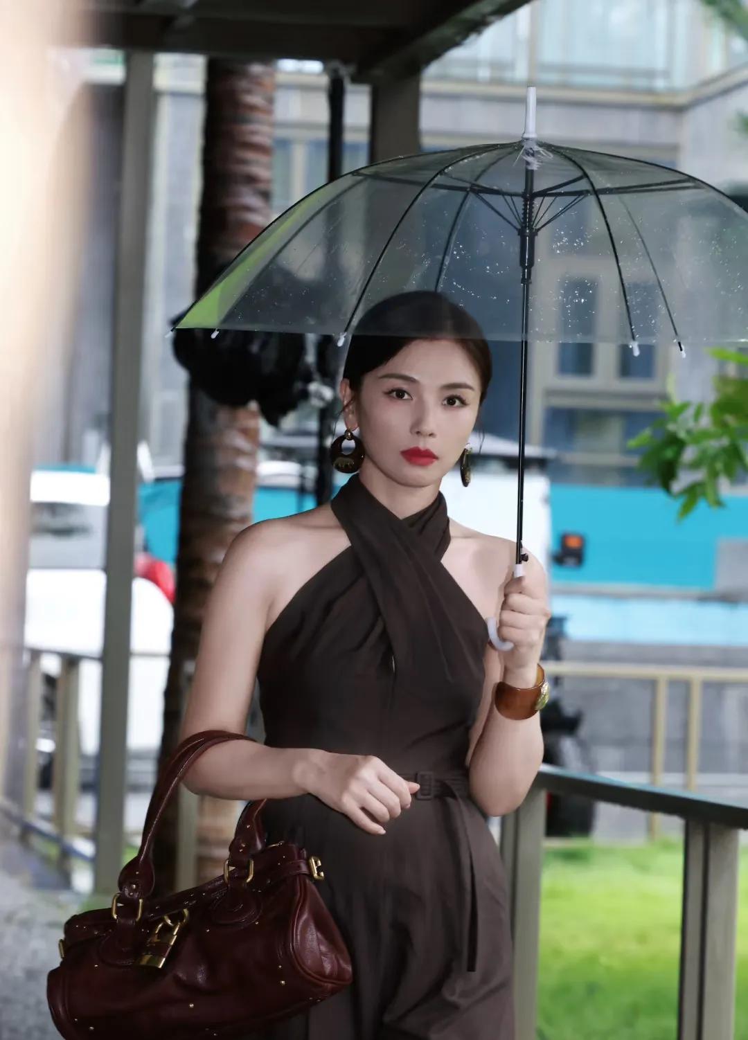 刘涛分享美照,深棕挂脖连身裤配低马尾,雨中持伞尽显优雅酷飒