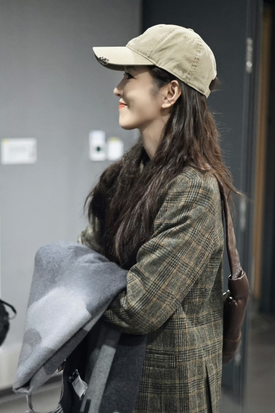 李云霄现身机场,长发配卡其棒球帽,格纹西装穿出慵懒高级感
