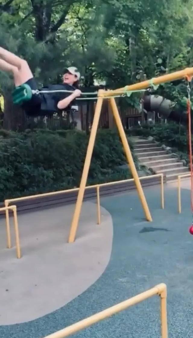 孙艺珍在公园玩秋千,她荡的好高,儿子甜豆向她挥手,玄彬站旁边