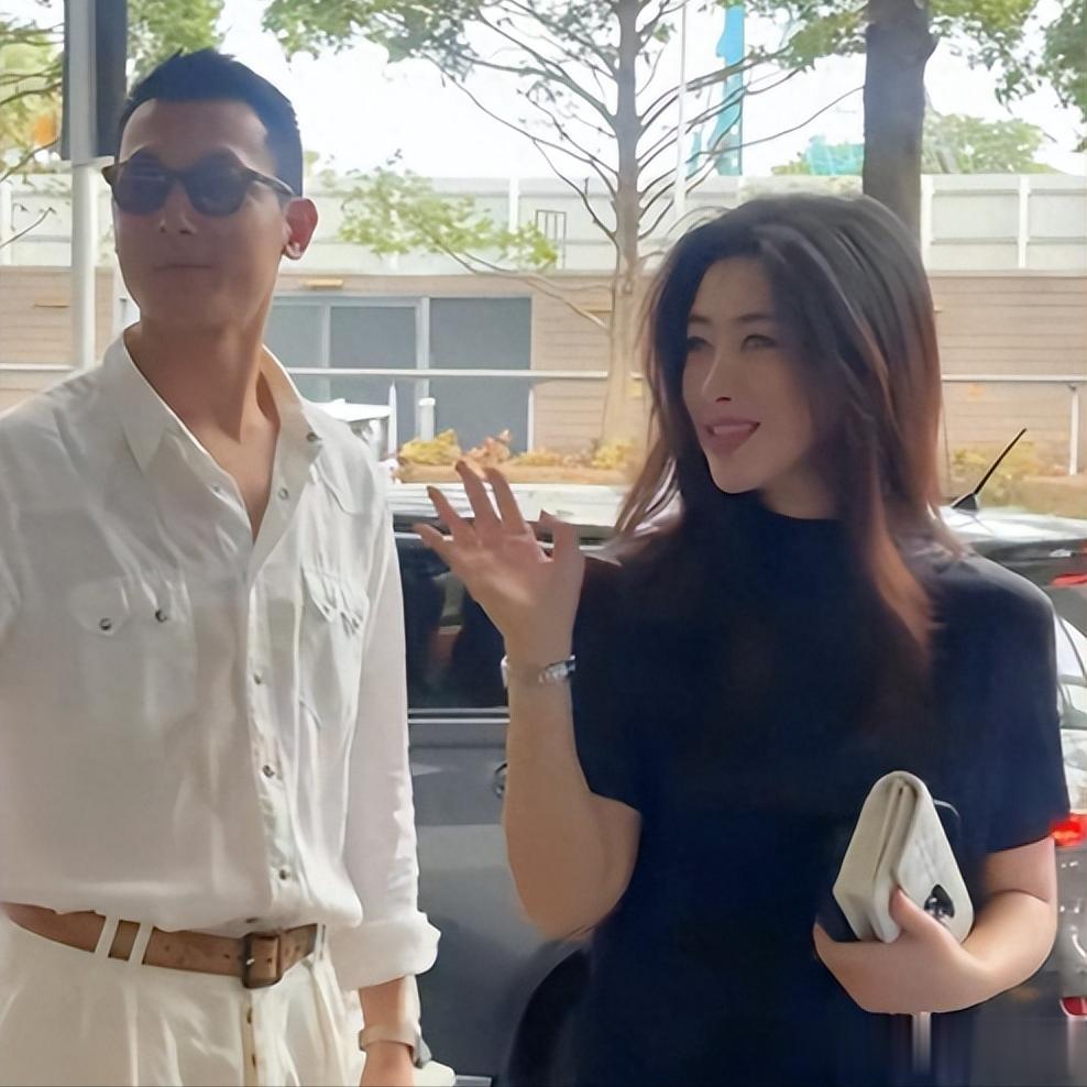 朱珠和老公在新加坡路边等车,她的老公身材高大,长相英俊。